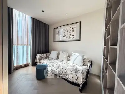 Elegant living room with stylish sofa, modern decor, and ample natural light through large windows.