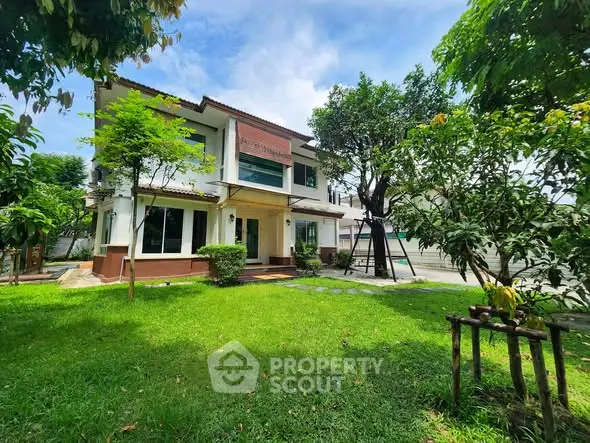 Stunning two-story house with lush green garden and modern architecture.