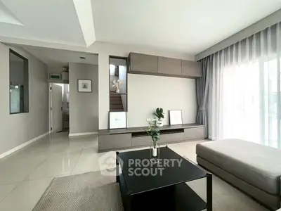 Modern living room with sleek furniture and large windows for natural light.