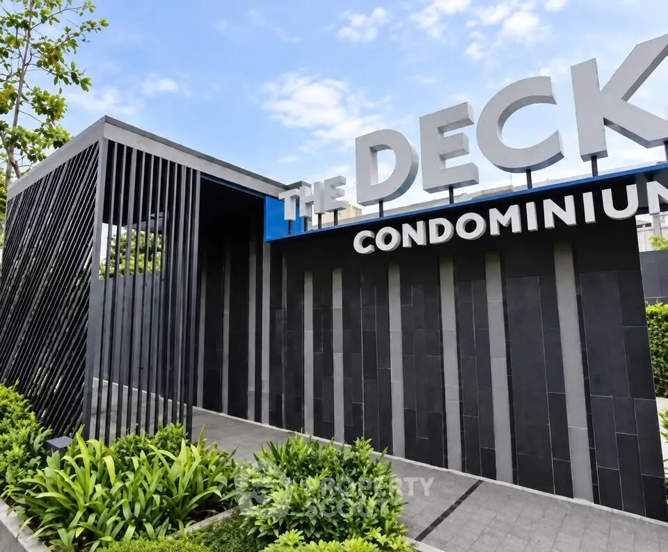Modern condominium entrance with sleek design and lush greenery