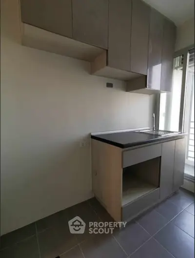 Modern compact kitchen with sleek cabinetry and natural light