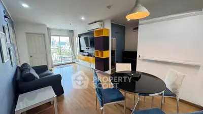 Modern living room with stylish furniture and city view, featuring a cozy seating area and vibrant decor.