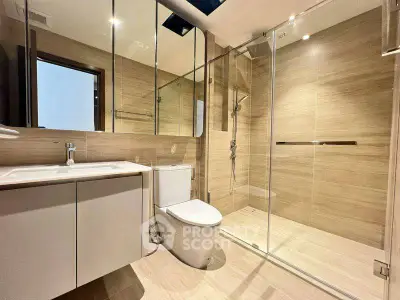Modern bathroom with glass shower and sleek fixtures in a contemporary home.