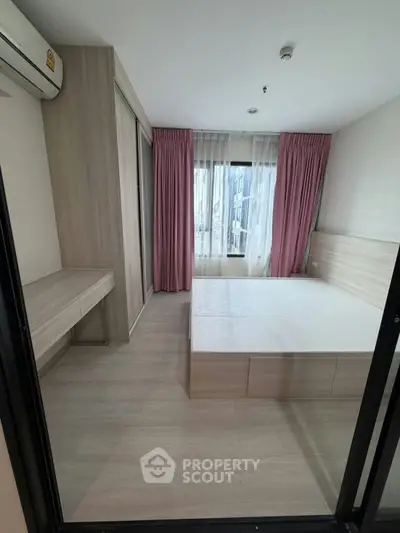 Modern bedroom with stylish wooden furniture and pink curtains, offering a cozy and inviting atmosphere.