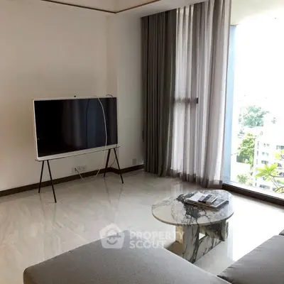 Modern living room with sleek TV, marble coffee table, and large window with city view.