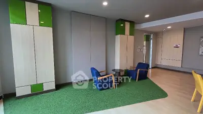 Spacious modern living room with vibrant blue armchairs, artificial grass area rug, and sleek white storage cabinets enhancing the contemporary vibe.