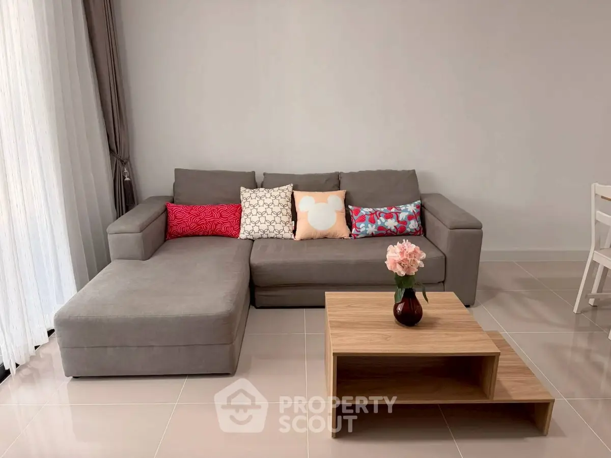 Modern living room with stylish gray sofa and wooden coffee table, perfect for cozy relaxation.