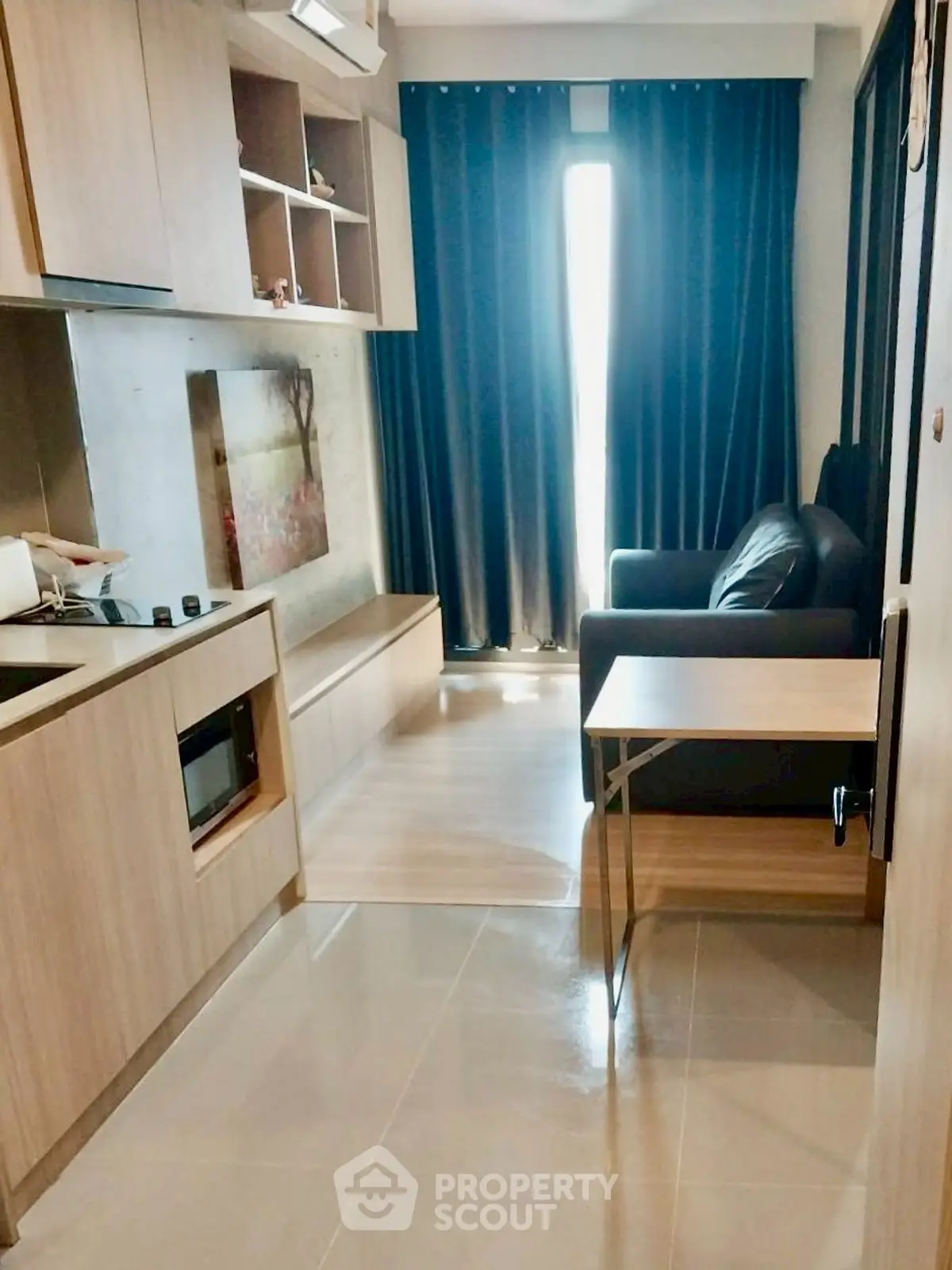 Modern compact living room with sleek wooden cabinetry and cozy seating area.