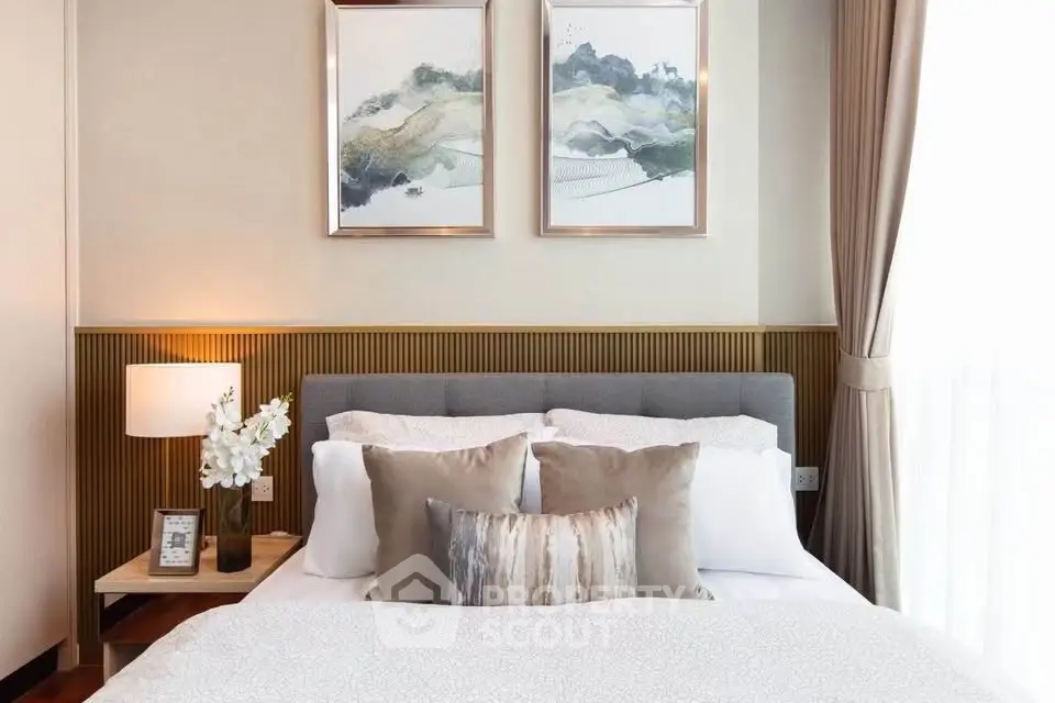 Elegant bedroom with stylish decor and natural light, featuring a cozy bed and modern artwork.