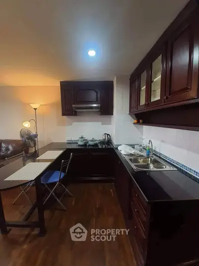 Cozy kitchen with dark wood cabinets and dining area, perfect for intimate gatherings.