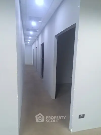 Modern corridor with sleek design and recessed lighting in a contemporary building.