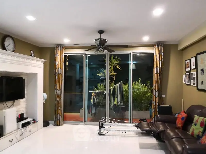 Spacious living room with modern decor and large sliding glass doors leading to a balcony.