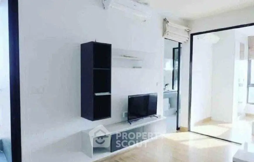 Modern living room with sleek TV unit and ample natural light