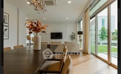 Luxurious modern living room with elegant decor and large windows overlooking a lush garden.