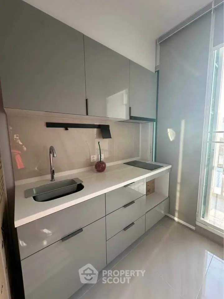 Modern kitchen with sleek grey cabinets and natural light