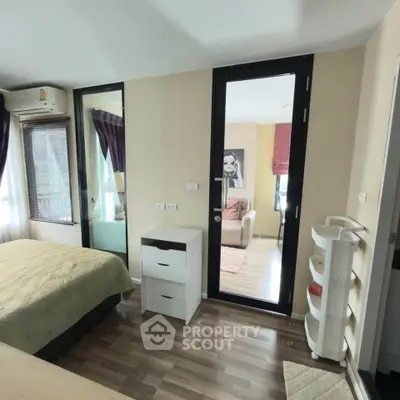Spacious bedroom with modern decor and natural light in a stylish apartment.
