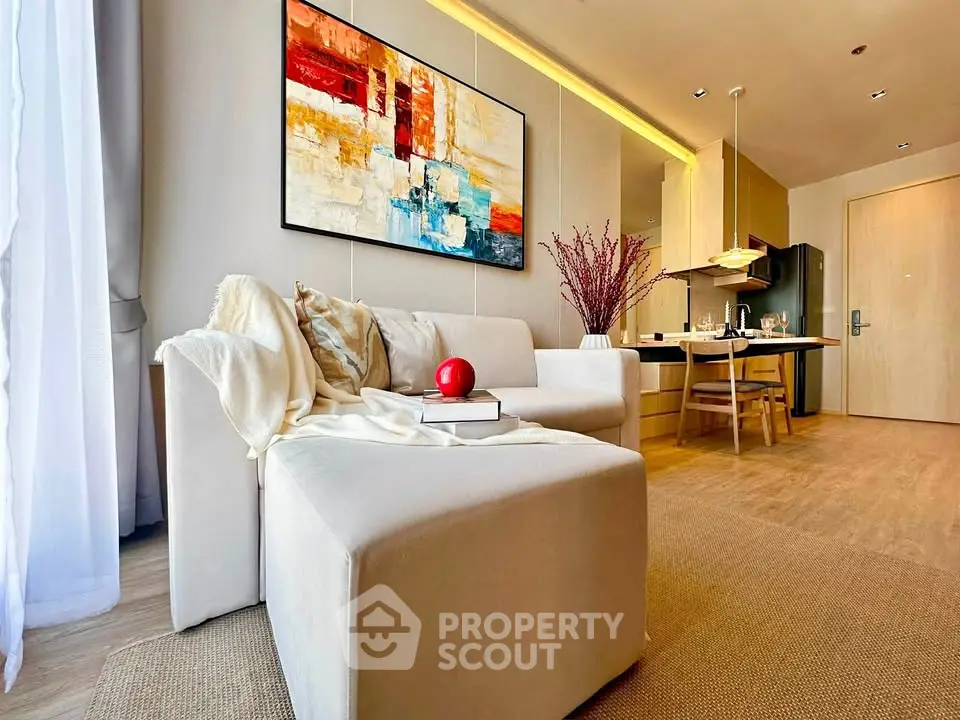 Modern living room with cozy seating and stylish kitchen in open layout apartment.