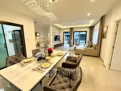 Luxurious open-plan living and dining area with elegant decor and modern lighting.