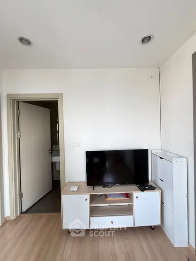 Modern living room with sleek TV stand and minimalist decor, perfect for urban living.