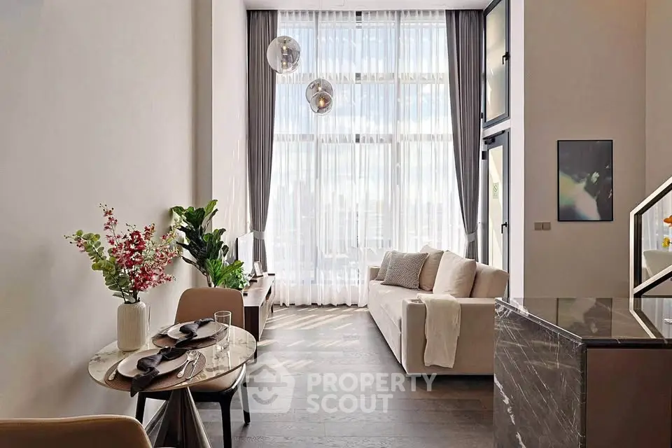 Luxurious high-ceiling living room with elegant decor and floor-to-ceiling windows.