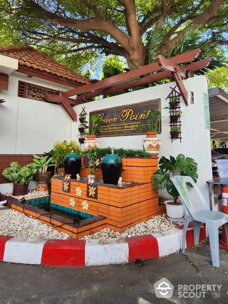 Charming garden entrance with decorative fountain and lush greenery in Bangkok property.