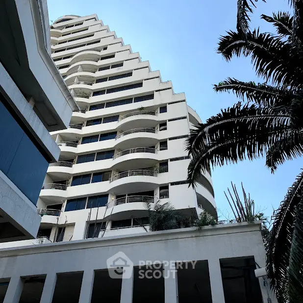 Stunning architectural building with unique stepped design and lush palm trees.