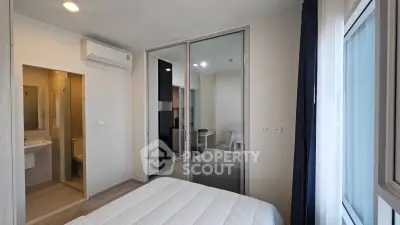 Modern bedroom with mirrored closet and ensuite bathroom in a stylish apartment.