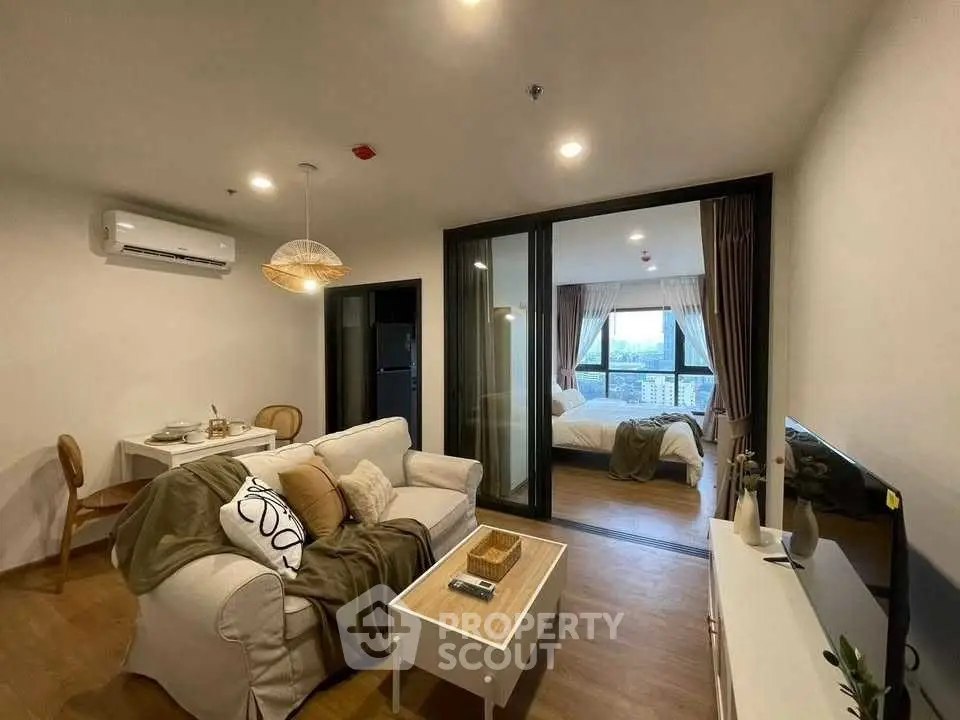 Modern open-plan living room with cozy bedroom view