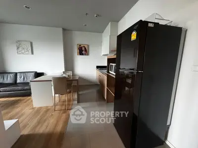 Modern open-layout kitchen with sleek black fridge and cozy dining area.