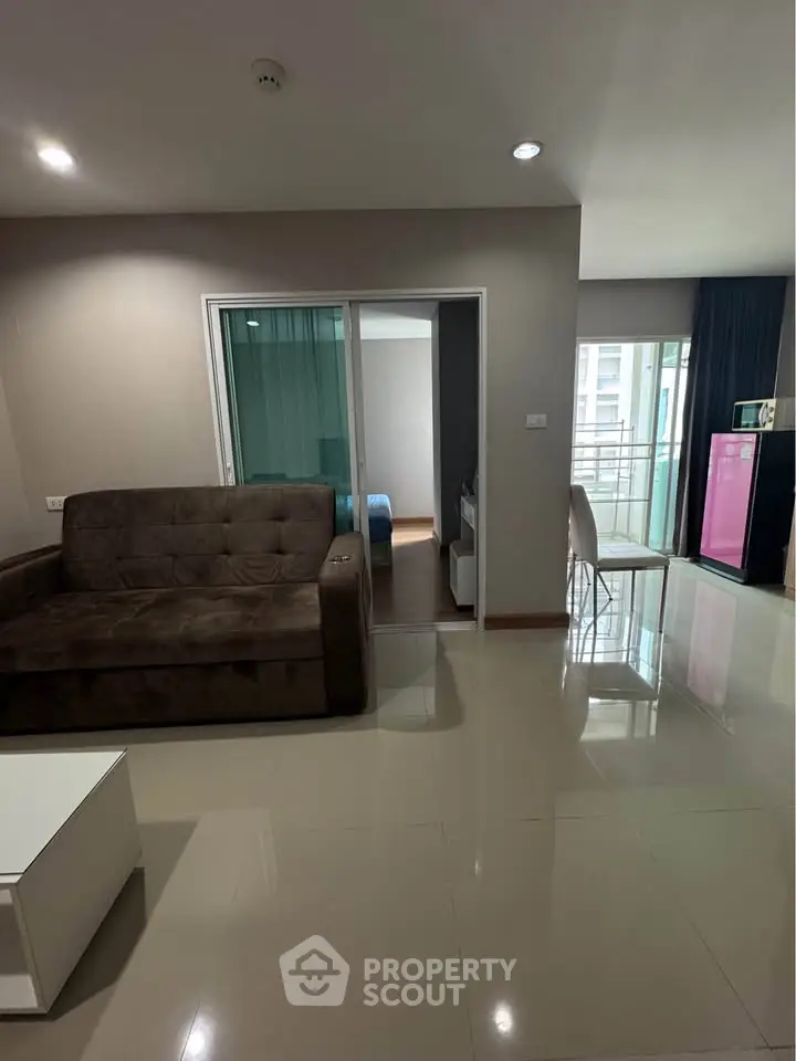 Modern living room with sleek furniture and balcony view in a stylish apartment.