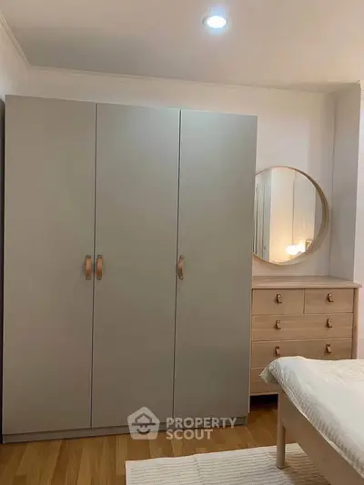 Cozy bedroom with modern wardrobe and stylish dresser mirror