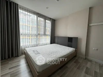 Spacious bedroom with large windows and modern decor in a stylish apartment.