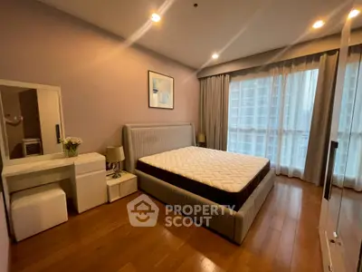 Spacious bedroom with modern decor and large window for natural light.