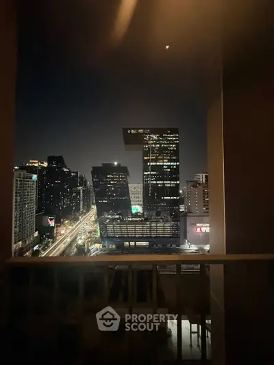 Stunning night cityscape view from a balcony overlooking modern skyscrapers.