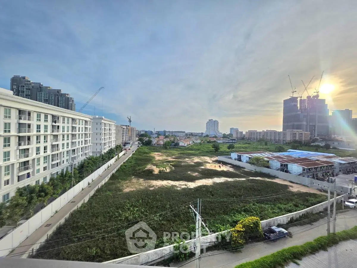 Stunning urban landscape view with modern buildings and construction site at sunset.