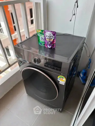 Modern washing machine on balcony with detergent packs, ideal for urban living.