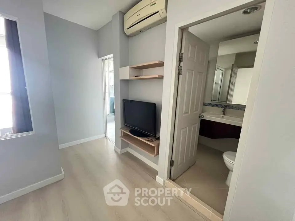 Modern compact living space with TV and bathroom access