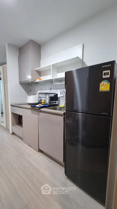 Modern kitchen with sleek cabinets and stainless steel appliances in a stylish apartment.