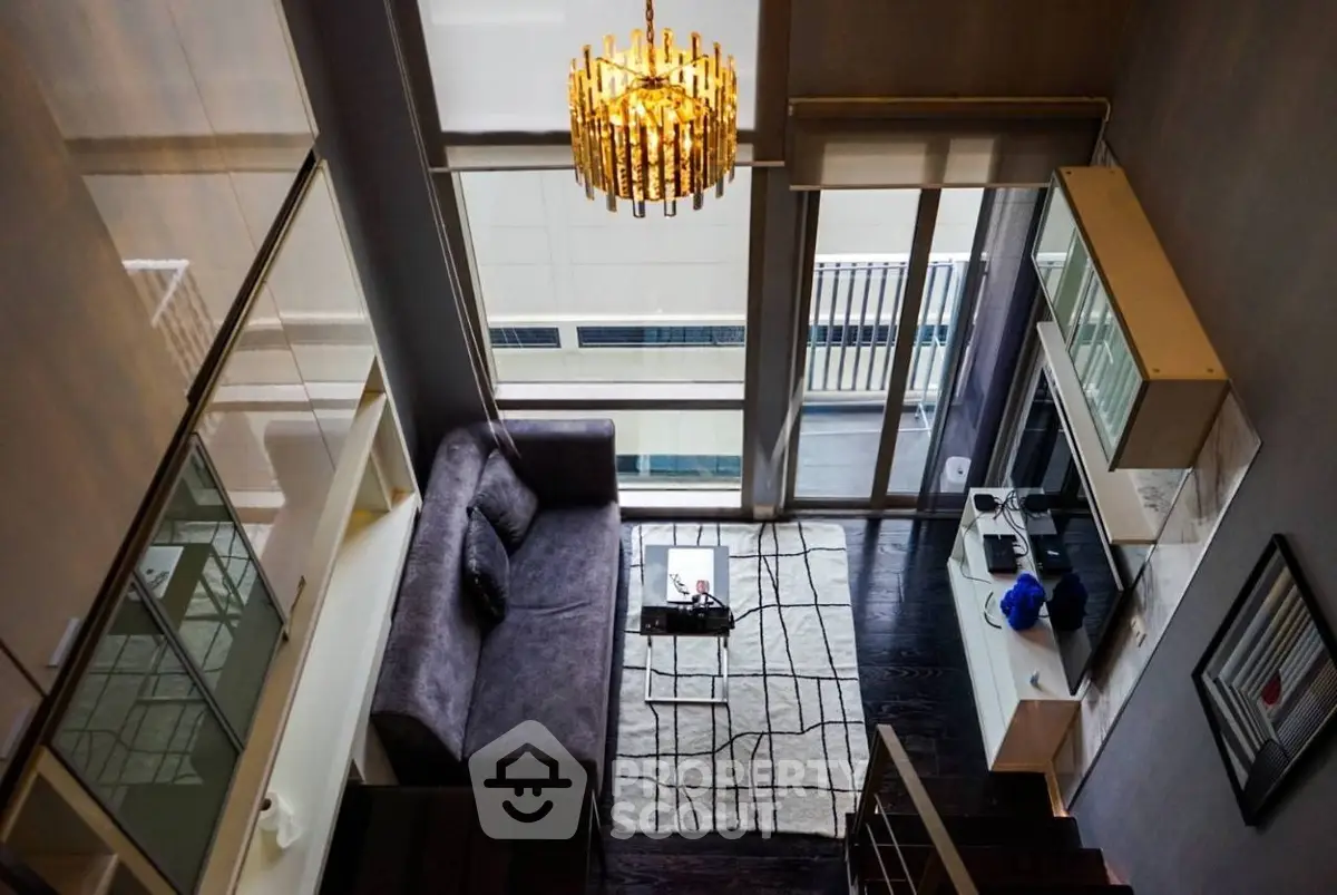 Luxurious modern living room with high ceiling and elegant chandelier in a stylish apartment.