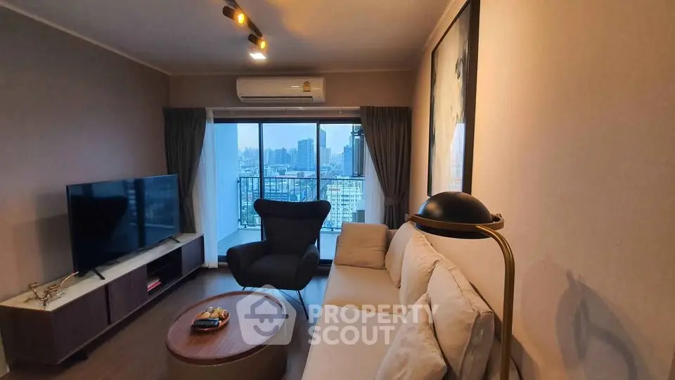 Stylish living room with city view, modern furniture, and large windows in a high-rise apartment.