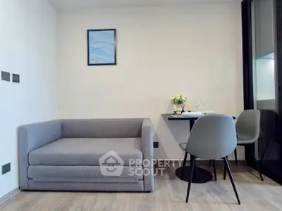 Modern living room with stylish gray sofa and elegant dining setup, perfect for cozy urban living.