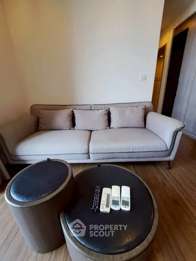 Modern living room with stylish sofa and round coffee tables in cozy apartment.