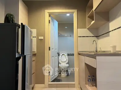 Compact kitchen with adjacent bathroom in modern apartment