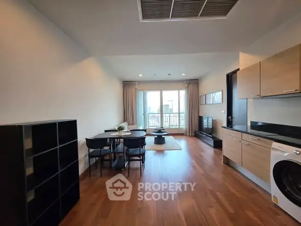 Spacious modern living room with open kitchen and balcony view