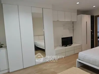 Modern bedroom with sleek white furniture and built-in storage solutions