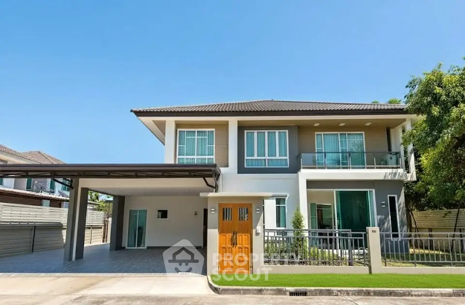 Modern two-story house with spacious driveway and elegant facade.