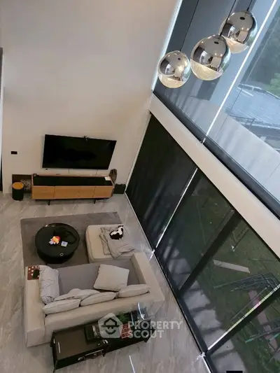 Spacious modern living room with high ceilings and large windows offering natural light.