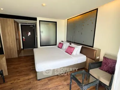 Modern bedroom with wooden flooring and stylish decor in a cozy apartment.