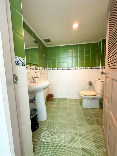 Charming bathroom with green tiles and modern fixtures