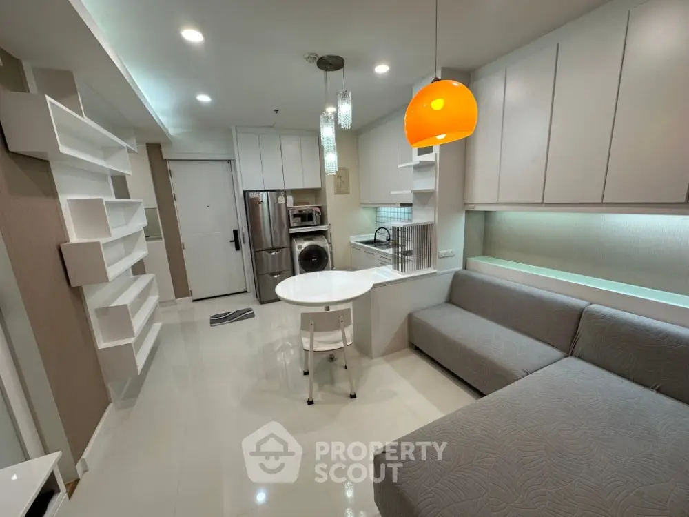 Modern open-plan living room with sleek kitchen and stylish lighting